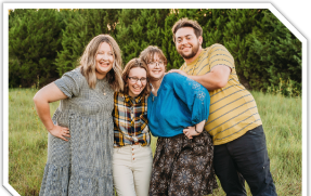 Four adult children in a sunny field
